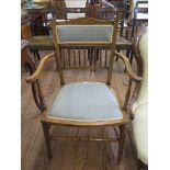 An Edwardian beech open armchair, the inlaid top rail over a padded back and turned spindles over