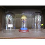 A pair of circular 3.5cm x 20cm clear glass domes, together with a small glass dome and stand with