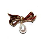 A diamond set red enamel bow brooch with pearl drop