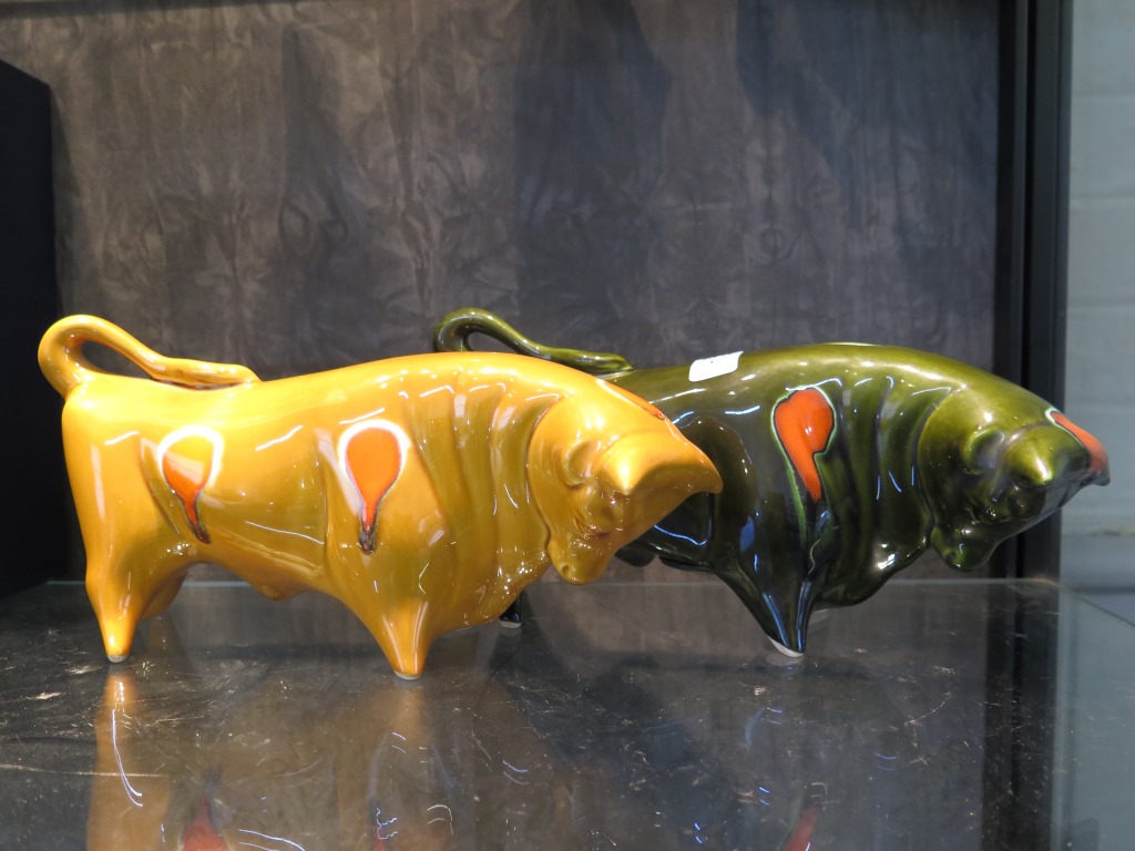 A Trentham art ware figure of a bull in yellow glaze, 30cm long, and another as a money box in green