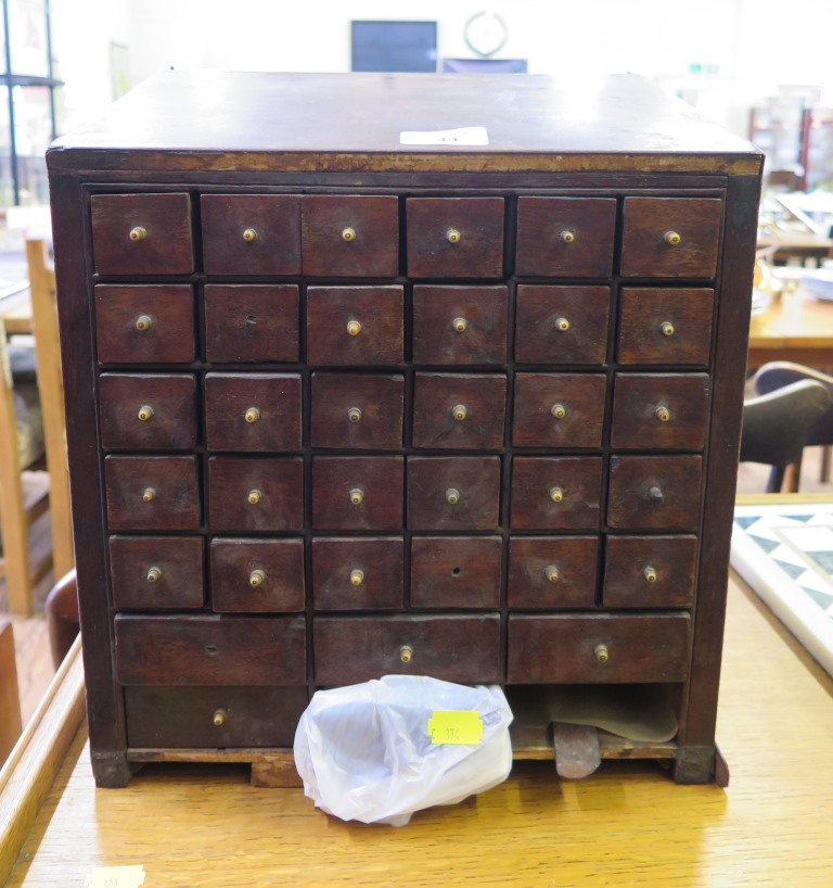 A 19th century mahogany apothecary cabinet, the sloping top over 30 small drawers and six larger
