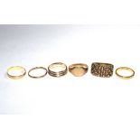 A collection of gold rings three 9 carat, one 14 carat, one 18 carat and one 22 carat