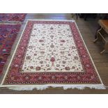 *A Keshan style rug, the beige field with all over scroll design within a red border, 244cm x 160cm