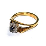 An 18 carat gold ring set with a diamond and sapphire cluster