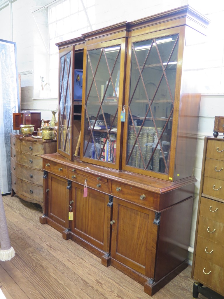 A Regency mahogany bookcase cabinet, the breakfront top with three glazed doors over a straight base