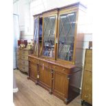 A Regency mahogany bookcase cabinet, the breakfront top with three glazed doors over a straight base