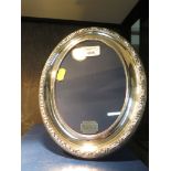 A silver oval photo frame by R. Carr with a decorative border, hallmarked Sheffield 1992,17.5cm x