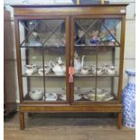 A mahogany and boxwood inlaid display cabinet, the husk inlaid frieze over a pair of glazed doors on