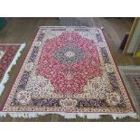 *A Keshan style rug, the red field with blue medallion and sand spandrels within a blue border 242cm