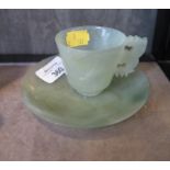A jade cup and saucer, with flat carved handle, saucer 11.5cm diameter