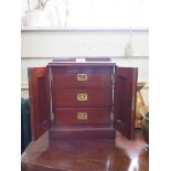 A Victorian mahogany table top cabinet, the cavetto top over a pair of arched panel doors