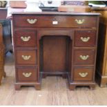 A George III crossbanded mahogany kneehole desk, the top with indented corners over a long drawer
