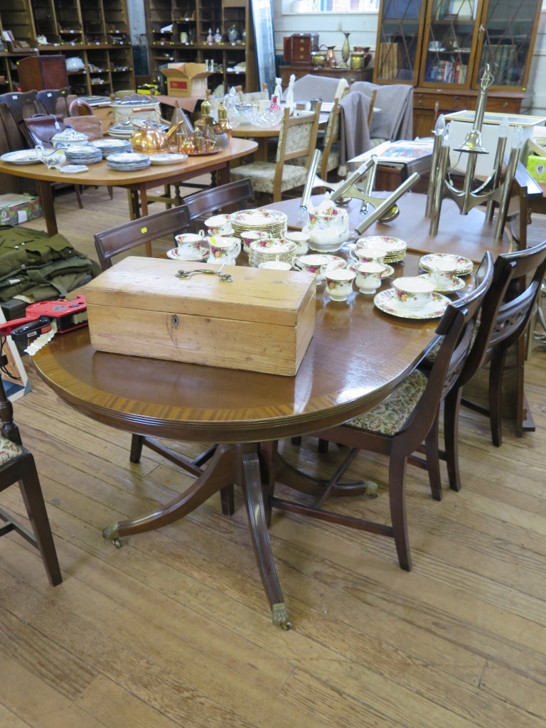 A reproduction crossbanded mahogany twin pedestal dining table, with an extra leaf and a set of