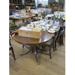 A reproduction crossbanded mahogany twin pedestal dining table, with an extra leaf and a set of