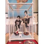 Two Japanese silk doll figures in traditional costume, in a glass display case, 54cm x 43cm high