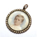 A portrait brooch of a young child, set in seed pearls