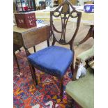 An Edwardian inlaid mahogany side chair, the shield back carved with scrolls and drapes above an