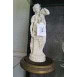 A Parian figure of a goddess holding a garland of grape vines 26cm high