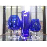 A cobalt blue cylindrical vase, 30cm high and two similar goblet vases, 25cm and 21cm high (3)