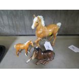 A Beswick Palomino horse, with one leg raised 17cm high, a miniature Beswick horse and another of