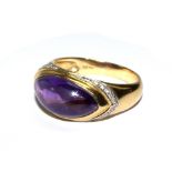 An 18 carat gold ring set with oval cabochon amethyst with attending diamonds