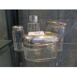 Four glass vanity bottles with silver tops