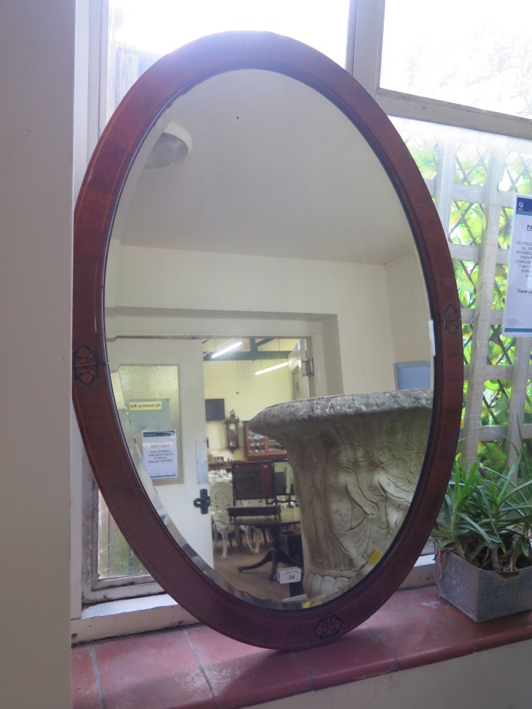 An inlaid mahogany oval mirror with bevelled plate 102.5cm x 72cm