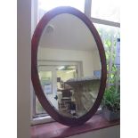 An inlaid mahogany oval mirror with bevelled plate 102.5cm x 72cm