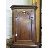 A George II oak corner cupboard, the dentil cornice over an arched door with patera inlay, 75cm wide