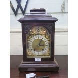 An Edwardian mahogany mantel clock in the George III style, the caddy top with brass handle over