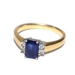 An 18 carat gold ring set with good colour trap cut sapphire with two diamonds either side