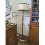 A 1920s turned oak standard lamp, with original silk tassled shade