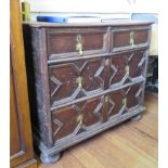 An early 18th century panelled oak chest of drawers with two short and two long graduated drawers on