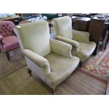 A pair of upholstered armchairs, with scroll arms and cabriole legs on later castors (2)