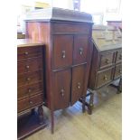 An inlaid stained beech gramophone cabinet, the frieze inlaid with swags, over twin cupboard