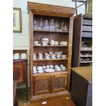 An Oriental bookcase cabinet, with three fixed shelves over latticework doors on a plinth base,