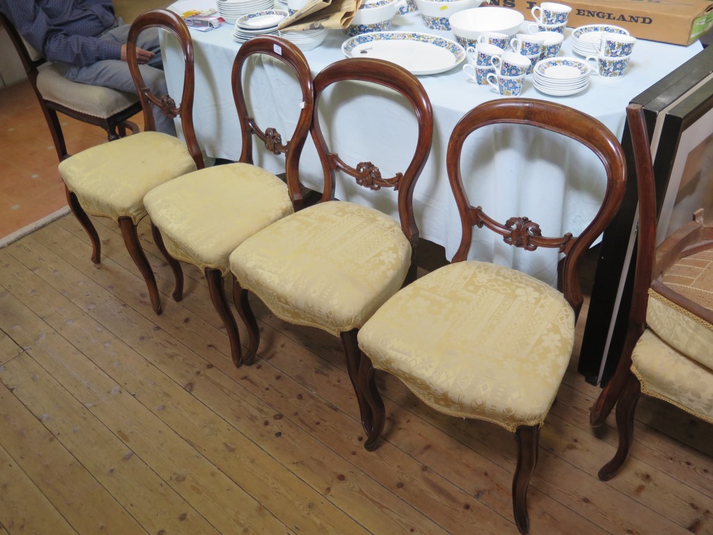 A set of six Victorian balloon back salon chairs, with carved mid rails, stuffover seats and moulded