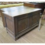 An 18th century style oak coffer, with hinged lid over a twin panelled arcade carved front, 99cm