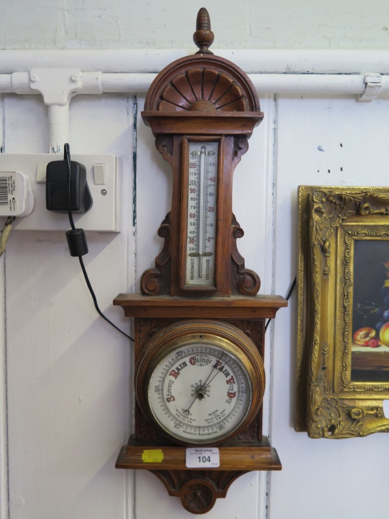 An Edwardian aneroid barometer with rosette and scroll carved frame and thermometer 59cm high