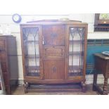An oak secretaire display cabinet, 1940s, the central cupboard door above a secretaire drawer and