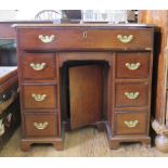 A George III crossbanded mahogany kneehole desk, the top with indented corners over a long drawer