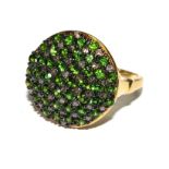 A gold colour metal ring set with diamond and green stone cluster