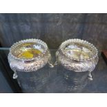 A pair of round silver open salts highly decorated in relief, engraved crest on the cartouche, on