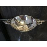 A white metal Quaich style dish