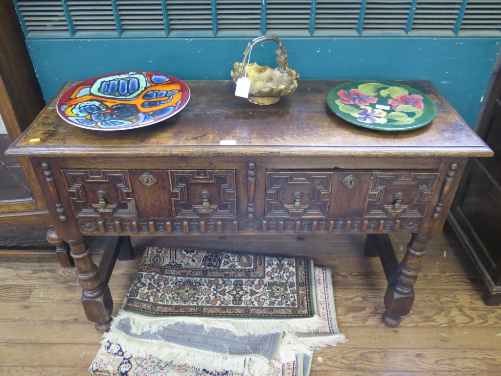 A Jacobean style oak dresser with two panelled drawers on turned legs joined by stretchers 122cm