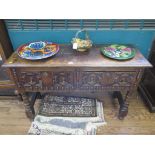 A Jacobean style oak dresser with two panelled drawers on turned legs joined by stretchers 122cm