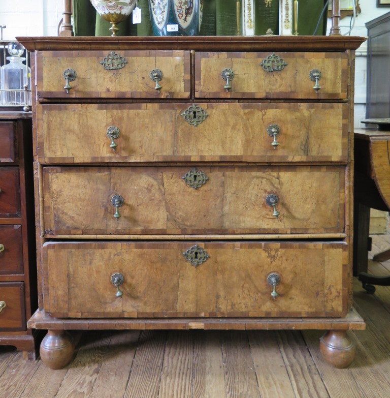 A Queen Anne crossbanded walnut chest of drawers, with two short and three long graduated drawers on