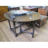 An 18th century oak gateleg table, the oval top over a foliate carved frieze and bobbin turned