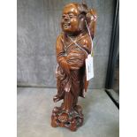 A Chinese carved wood figure of an elder holding a basket 30.5cm high
