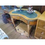 A French style mahogany kidney-shape writing table, the leather inset top over an inlaid frieze with